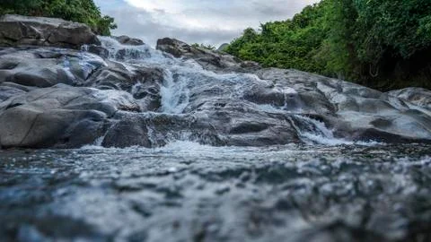 A waterfall that formed from a mountain river. Stock Photos