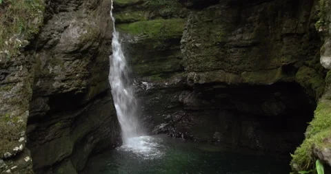 Waterfall forms a small lake with green colored waters Video stock 190481791
