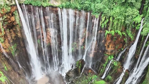 This waterfall forms a wide curtain beneath volcanic cliffs Stock Footage 340268013