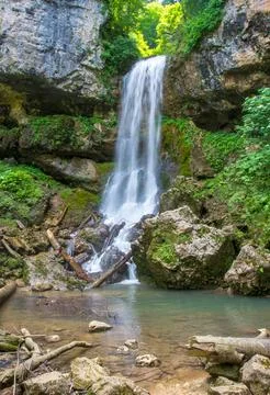A waterfall, a fragment of a mountain river in the embrace of a stone canyon Stock Photos