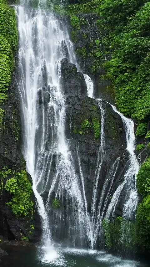 Waterfall in green rainforest. Breathtaking vertical aerial view of powerful Stock Footage 270172943