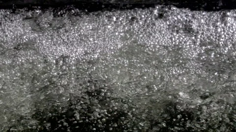 Waterfall from a height falls onto the water surface below until it foams. Stock Footage 294984832