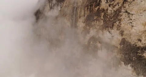 Waterfall hidden in the clouds beautiful rock face in the Dolomites. Aerial Stock Footage 132112518