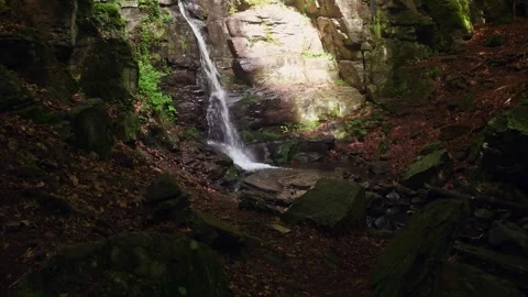 Waterfall in the light of the sun's rays in the forest 스톡 동영상 275573283