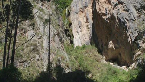 Waterfall located between two mountains in the distance. Stock Footage 337409693
