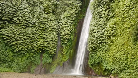 Waterfall low part streaming into lake between green cliffs Video stock 102104877