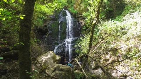 Waterfall in the middle of the forest or woods and girl relaxing in nature Vidéo 285768211