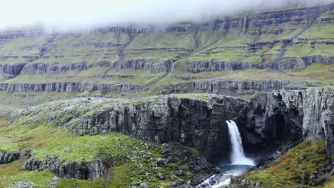 A waterfall with a mountain in the background Stock Footage 156010354