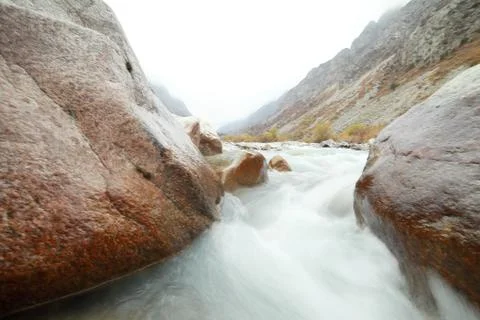A waterfall with a mountain in the background Stock Photos