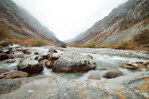 A waterfall with a mountain in the background Stock Photos