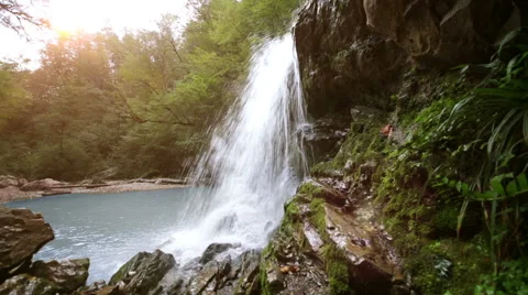 Waterfall in mountain forest with sun Stock Footage 43316503