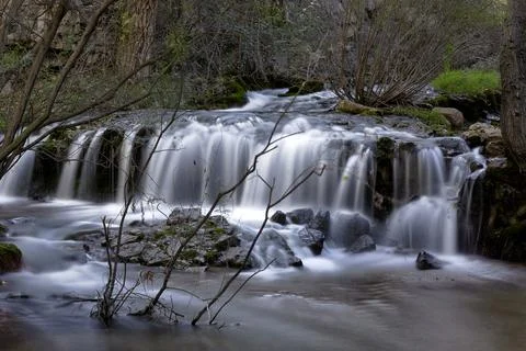 Waterfall in a mountain river in long exposure Stock Photos