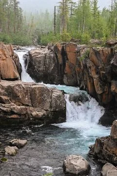 Waterfall on a mountain stream. Stock Photos