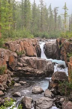 Waterfall on a mountain stream. Stock Photos
