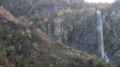 Waterfall in the mountains, among rocks, trees, green vegetation. Stock Footage 221301670