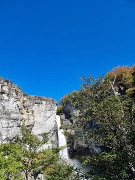 Waterfall in the mountains, blue sky Stock Photos