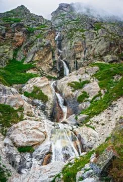 Waterfall in the mountains. Stock Photos