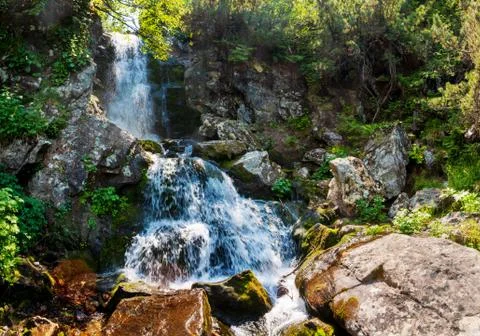 Waterfall in the mountains river. Panoramic view. Granite rock mountain. Stock Photos