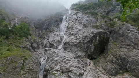 Waterfall in the mountains surrounded by mist Stock Footage 162196326