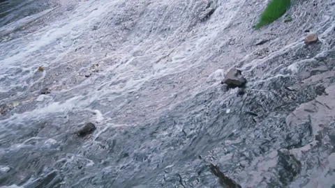 Waterfall in mountains, water flows down the stones turning into a stream Stock Footage 249282251