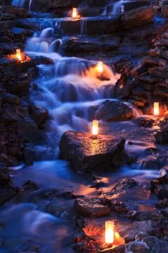 Waterfall with Multiple Candles at Twilight Stock Photos