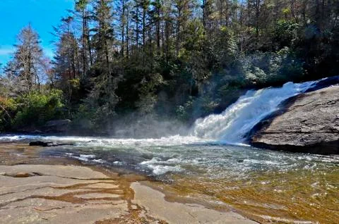 Waterfall over rocks with mist Stock Photos