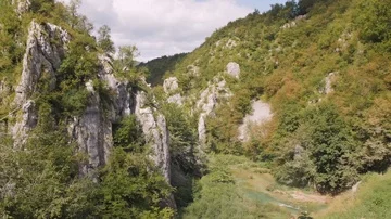 Waterfall pans into a beautiful landscape Stock Footage 85703323