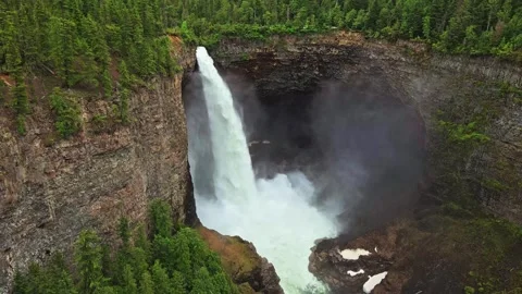 Waterfall plunging into deep canyon surrounded by forest aerial shot Stock-Footage 344137762