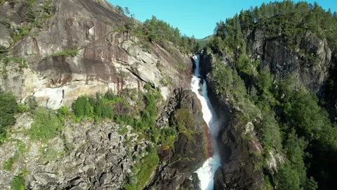 Waterfall plunging down granite cliff, aerial sideways, Norway Vídeos de archivo 347005939