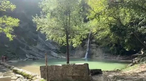 Waterfall pouring into green natural pool in forest Stock Footage 327623706