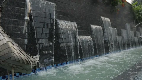 Waterfall pouring into a pool from stone wall at resort Stock Footage 120282619