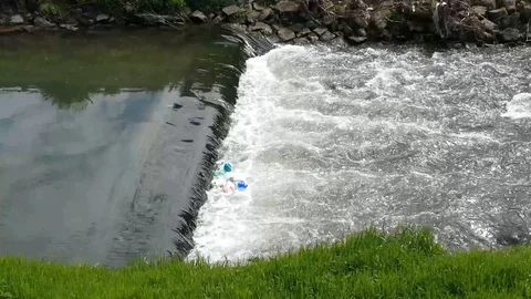 Waterfall on river with floating waste Video stock 91554313
