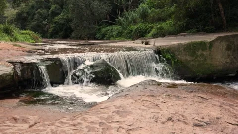 A waterfall in a river flowing over an ex road crossing in a nature reserve. Stock Footage 249716884