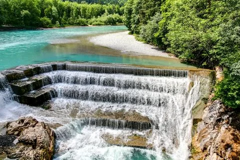 A waterfall with a river flowing underneath it Stock Photos