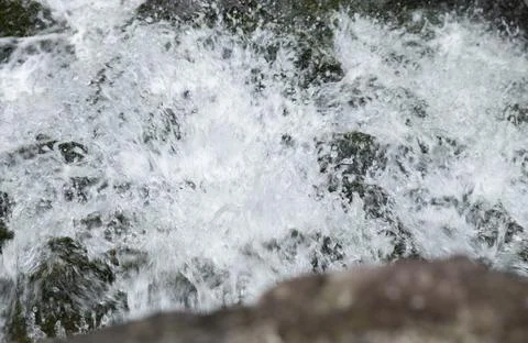 Waterfall on the river in the forest close-up macro photo. Abstract Background. Stock Photos