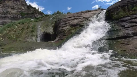 Waterfall of a river in full vegetation on a sunny day Stock Footage 132867038