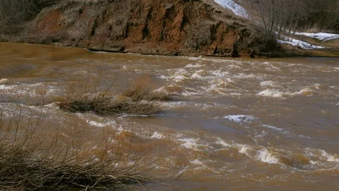 Waterfall on river near mountain at spring with naked bushes, flood, high water. Stock Footage 129602677