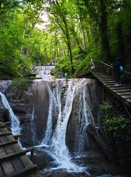 Waterfall on the road in the forest Stock Photos