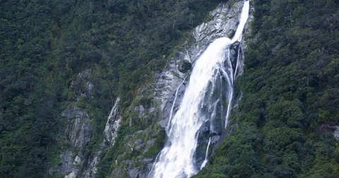Waterfall rolling down the green mountain slope Stock-Footage 93608455