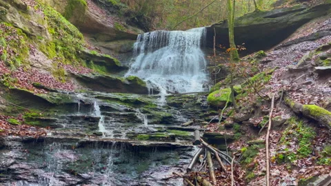 A waterfall with running water between mountains Stock Footage 221326176