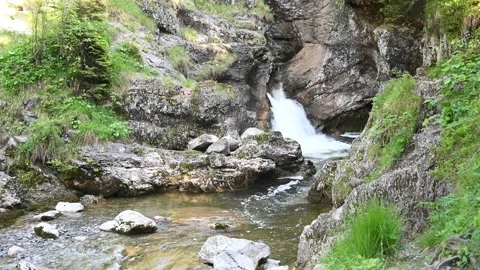 A waterfall runs between rocks in the mountains Stock-Footage 219351065