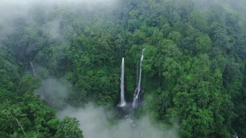 Waterfall seen through the clouds from above surrounded with fog and mist. Stock Footage 241403614