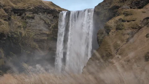 A waterfall is shown in the foreground of a mountain range Stock Footage 301791102