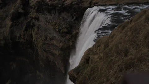 A waterfall is shown in the image, with the water falling down a steep cliff Video stock 301791890