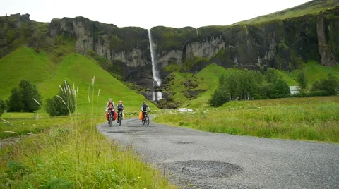 Waterfall at Sidu. Cyclists on the background of a waterfall. Iceland Stock Footage 59856770