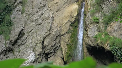 A waterfall in slow motion, water falling from a rocky steep mountain slope Video stock 236835201