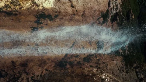 Waterfall on small rocks while the sun is shining. The waterfall makes Stock Footage 148887793