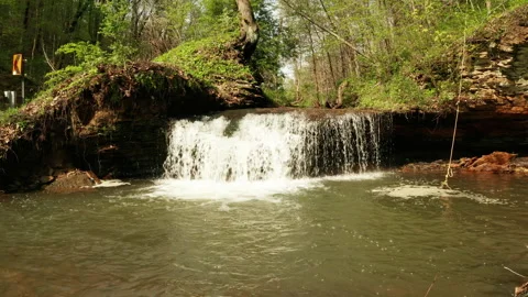 Waterfall spilling into a pond Stock Footage 153871457