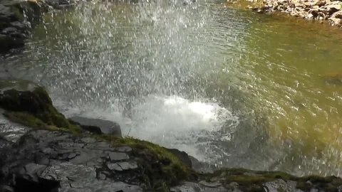 Waterfall spilling into pool seen from behind Stock Footage 92576259