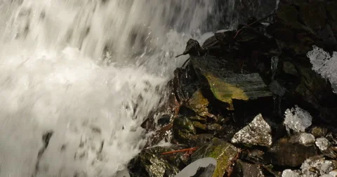 Waterfall in spring time with icicles on the rocks Stockbeeldmateriaal 60950108